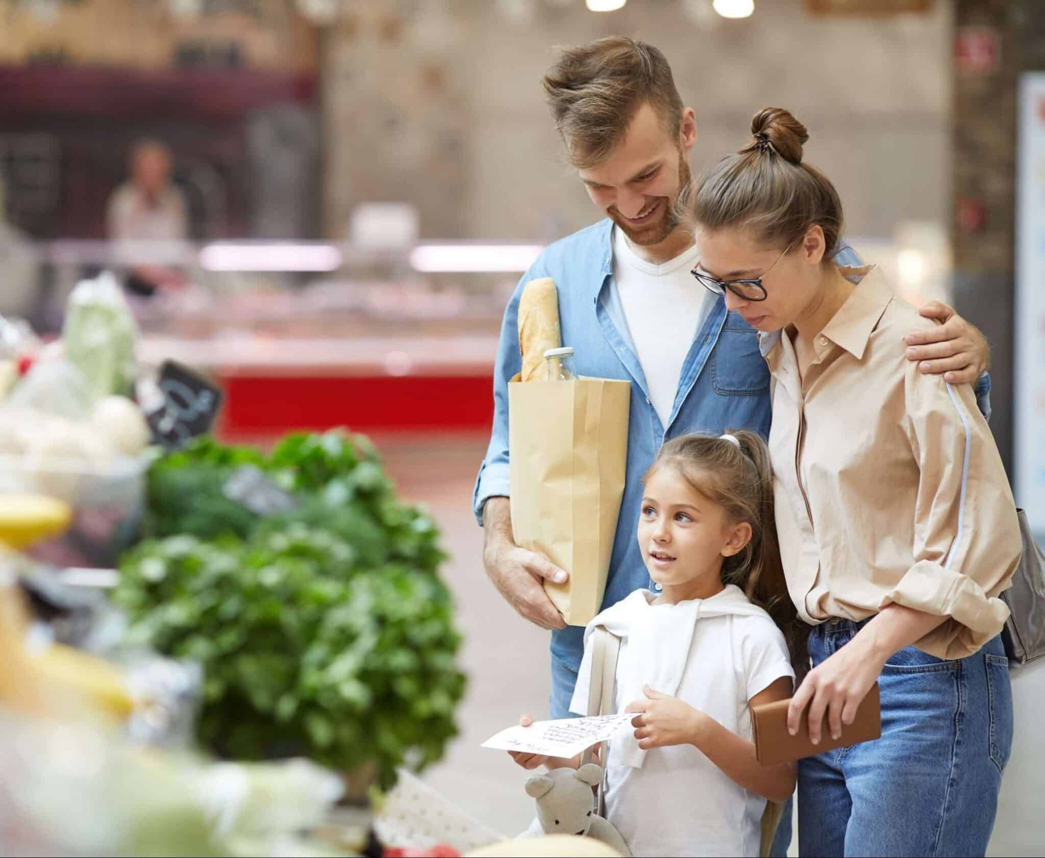 Portrait of contemporary young family buying groceries at farmers market, copy space